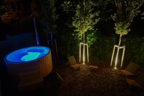 two trees and a hot tub in a yard at night at Boekelbaan 161 in Zwalm