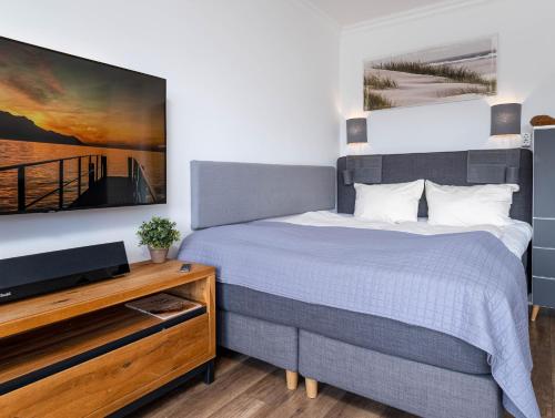 Schlafzimmer mit einem Bett und einem Flachbild-TV in der Unterkunft Ferienwohnung Abendsonne in Wenningstedt-Braderup