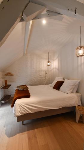 a bedroom with a large white bed with two lights at Boekelbaan 161 in Zwalm