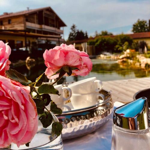a vase with pink roses sitting on a table at Ortner's Resort in Bad Füssing