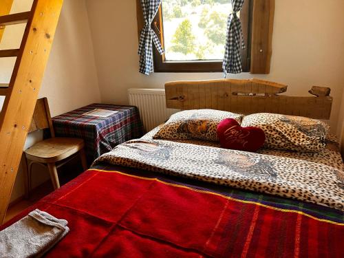 a bedroom with a bed with a red blanket on it at Tara Place - Camp Rabrenovic in Mojkovac