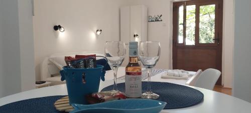 una mesa con una botella de vino y dos copas de vino en Apartment Cattaro magico en Kotor