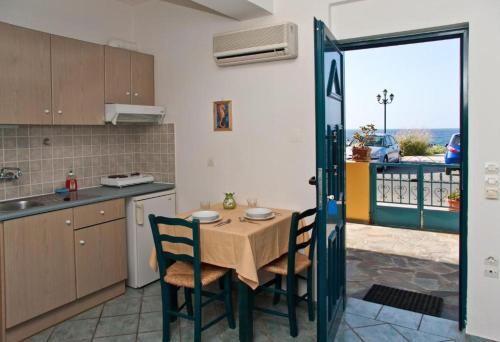 a kitchen with a table and chairs with a view at Marelina Villas in Panormos Rethymno