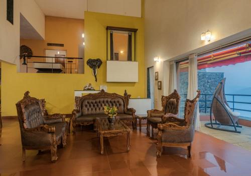 a living room with chairs and a table at SaffronStays Aurelia, Panchgani - Balinese villa with breathtaking valley views in Panchgani