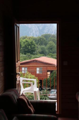 a window with a white chair in front of a house at Rosemary Pansiyon in Cıralı