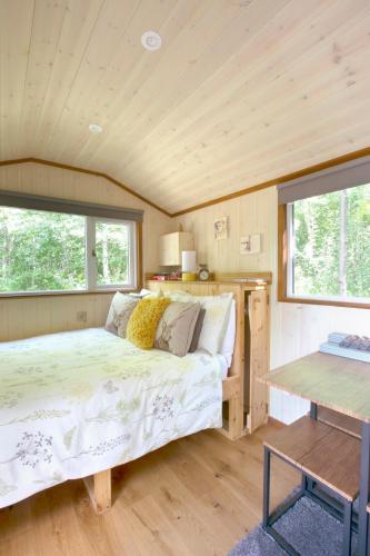 a bedroom in a tiny house with a bed at Riverwood Farms Shepherds Hut in Talaton