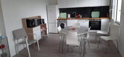 uma cozinha com mesa e cadeiras num quarto em Maison ville agréable em Riorges