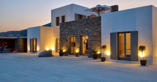 a building with a courtyard with potted plants and lights at Golden Bay luxury villas and suites in Chrissi Akti