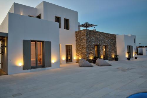 a white building with some pillows in a courtyard at Golden Bay luxury villas and suites in Chrissi Akti