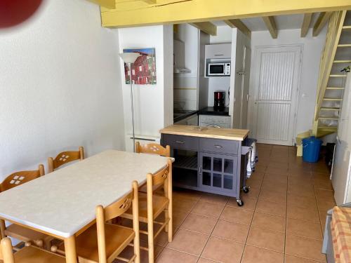 cocina con mesa y sillas en una habitación en Résidence LA CROISIERE, en Anglet