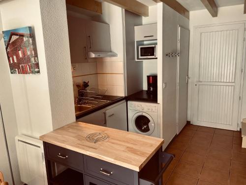 uma cozinha com um lavatório e uma máquina de lavar roupa em Résidence LA CROISIERE em Anglet