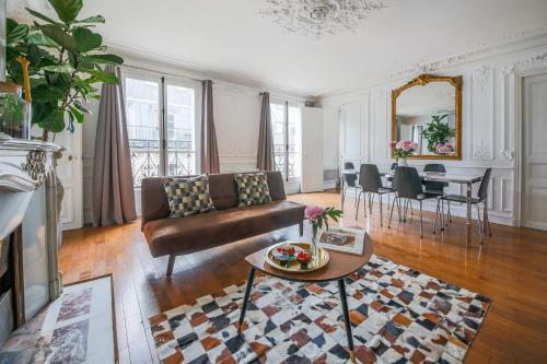 un salon avec un canapé et une table dans l'établissement Appartements Bergère, à Paris