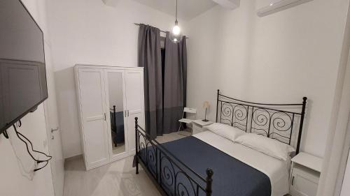 Dormitorio con cama negra y TV en Maison Don Turillo, en SantʼAlessio Siculo