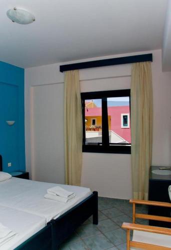 a bedroom with a bed and a window at Marelina Villas in Panormos Rethymno
