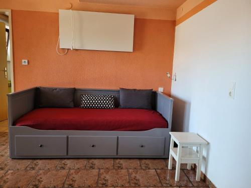 Bett in einem Zimmer mit einer roten Decke in der Unterkunft Appartment am Egghof in Oberperfuss
