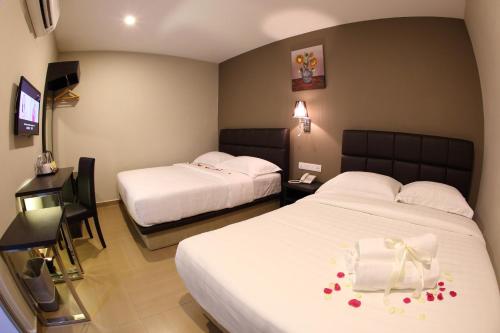 a hotel room with two beds with flowers on them at GL Hotel Kluang in Kluang