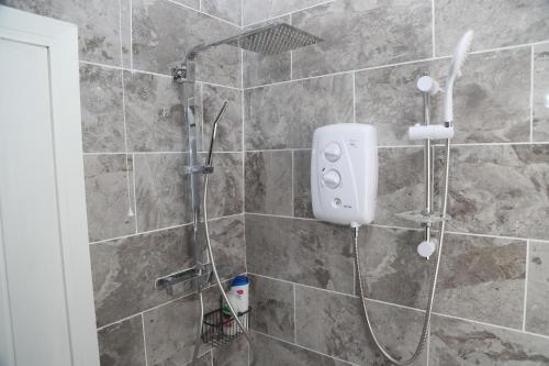 a shower with a shower head in a bathroom at Homely 1-Bed Apartment in Birmingham in Birmingham