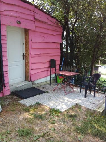 una casa rosa con una mesa y sillas frente a ella en LA CABANE, en Bellac