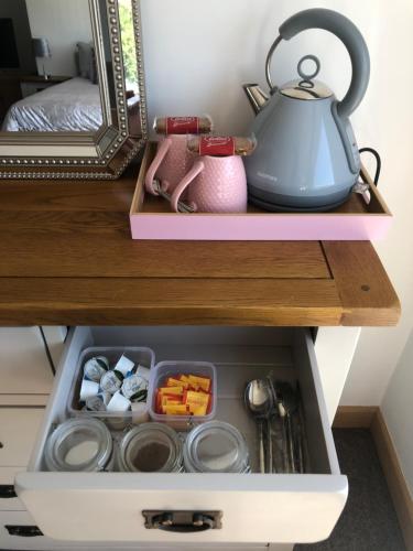 a drawer in a cabinet filled with food and a tea kettle at Very Large lovely double room loft apartment in Carlton Colville