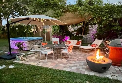 a patio with a table and chairs and an umbrella at Close to beaches with hot tub and large garden in Sarasota