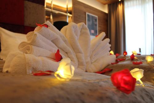 a bed with white towels and red roses on it at Ortner's Resort in Bad Füssing