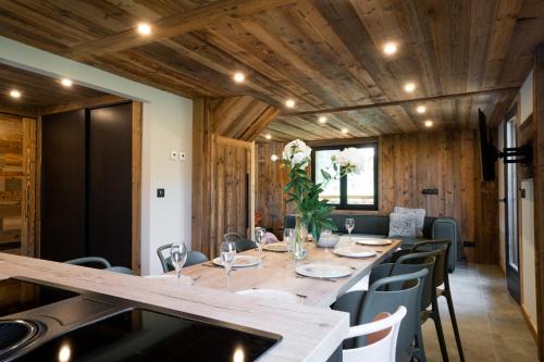 une salle à manger avec une longue table et des chaises dans l'établissement Le Petit Chalet de Montriond, à Montriond