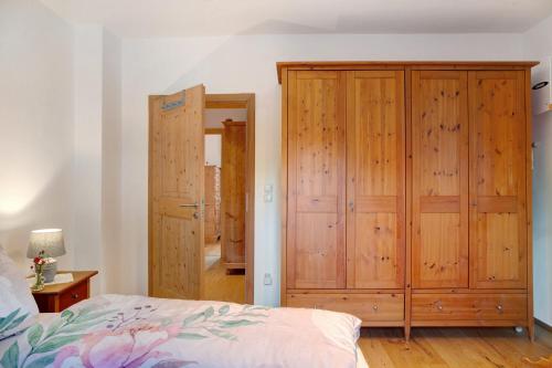 a bedroom with a wooden closet and a bed at Ferienwohnung Zugspitzblick in Grainau