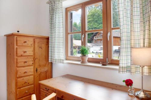 a room with a wooden desk and a window at Ferienwohnung Zugspitzblick in Grainau
