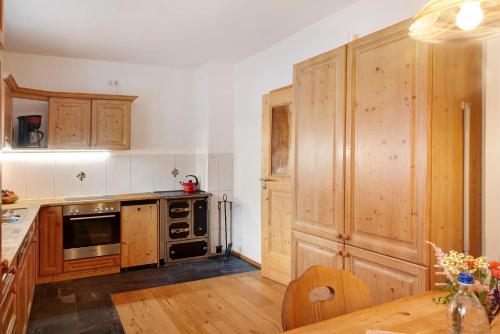 a kitchen with wooden cabinets and a wooden table at Ferienwohnung Zugspitzblick in Grainau