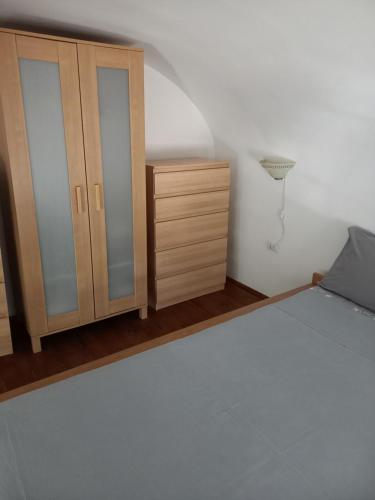 a bedroom with a bed and a wooden cabinet at RomaKumamoto in Rome
