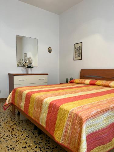 a bedroom with a bed with a colorful blanket at Palazzina Salodium INCANTO - ARMONIA - ENERGIA in Salò
