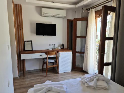 a bedroom with a desk and a television on a wall at in Ephesus Hotel and Art Galery in Selcuk