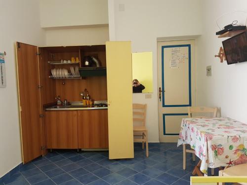 une cuisine avec une table et une table ainsi qu'une chambre dans l'établissement Lipari Centro Storico Flat 7 min from port, à Lipari