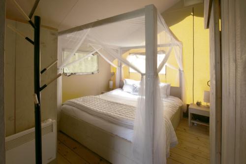 Кровать или кровати в номере Riverwood Farm Glamping Safari Tent