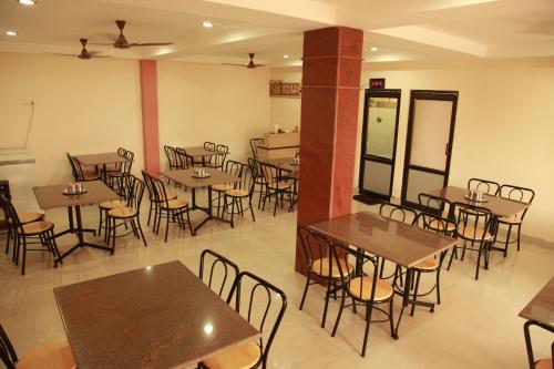 an empty dining room with tables and chairs at Jeyam Residency, Kumbakonam in Kumbakonam