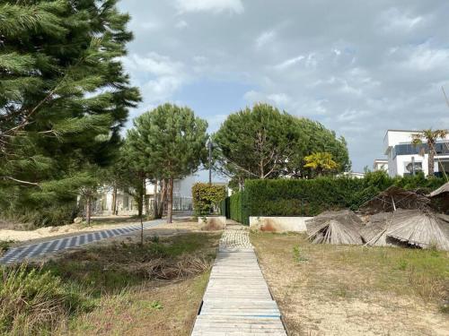 a walkway in a park with trees and a building at Blue Garden Villa, Gjiri i Lalezit in Durrës