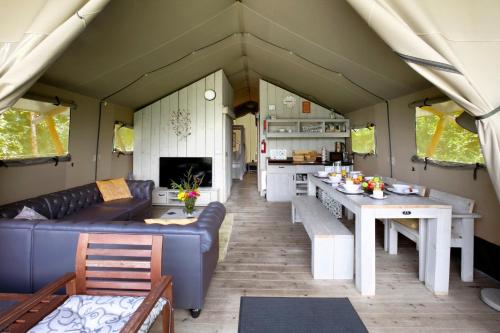 a living room and kitchen in a tiny house at Riverwood Farm Glamping Safari Tent in Talaton