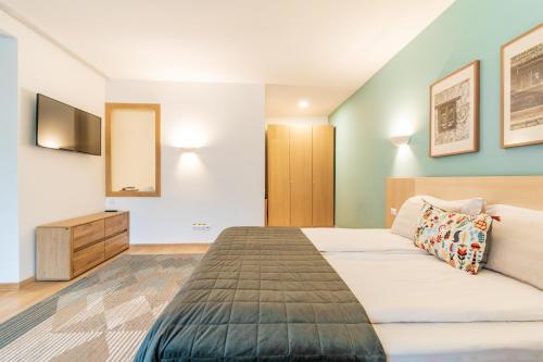 a bedroom with a bed and a tv on the wall at Cuibul de Lemn in Râşnov