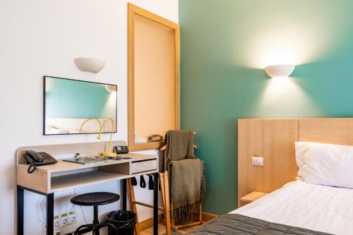 a hotel room with a desk and a bed and a mirror at Cuibul de Lemn in Râşnov