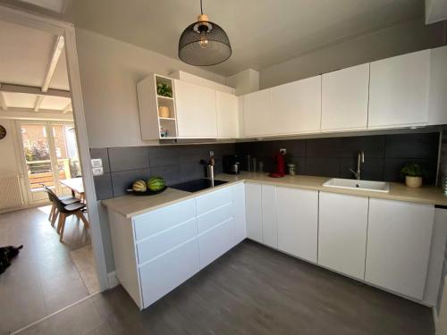 een keuken met witte kasten en een spoelbak bij L ETOILE DE MALO in Duinkerke