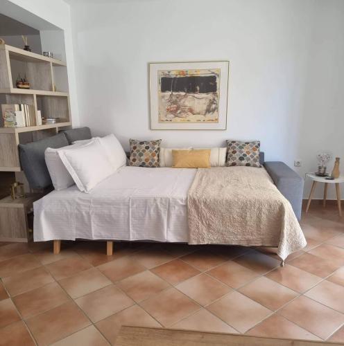 a bed with pillows on it in a room at AZALEA - Modern studio with sea view in Galatas