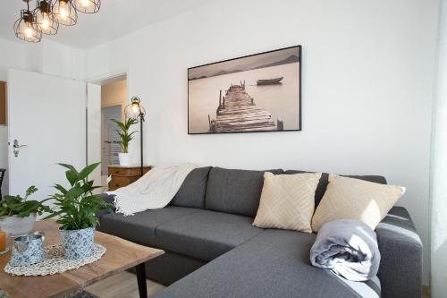 a living room with a gray couch and a table at Haus Rosi in Friedrichshafen
