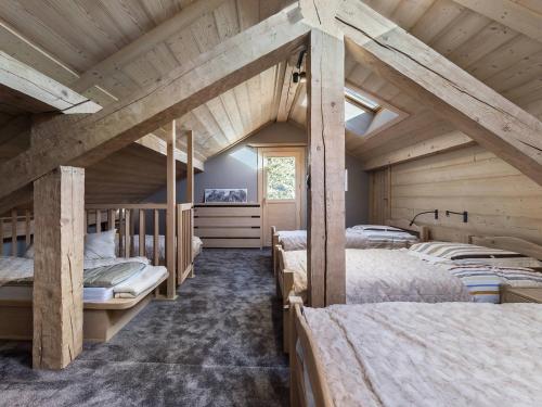 a bedroom with four beds in a room with wooden ceilings at Chalet Méribel, 5 pièces, 11 personnes - FR-1-565-46 in Les Allues