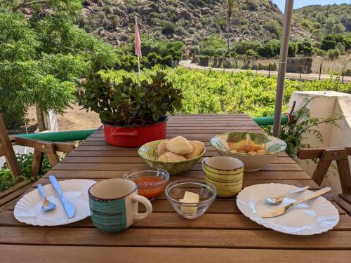 a wooden table with plates and bowls of food on it at Cala Vinagra House in Carloforte