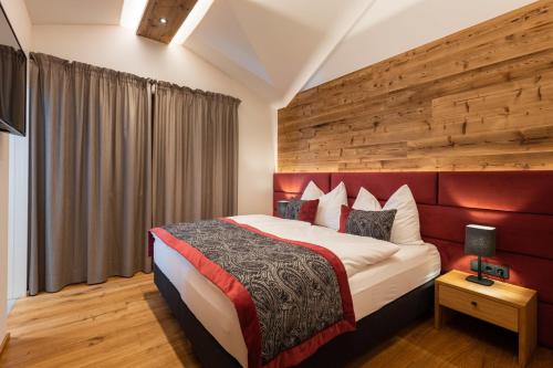 a bedroom with a large bed with a red headboard at Ferienlodge Edelstein in Forstau