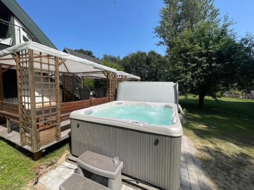 a hot tub on a patio next to a gazebo at Appartementhaus Brunsholm in Esgrus