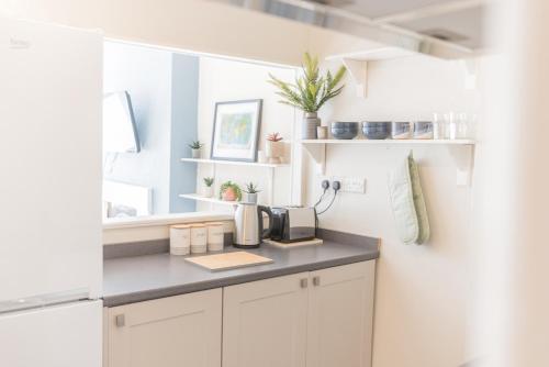 a kitchen with white cabinets and a counter top at 5A Queen Street in Whitehaven