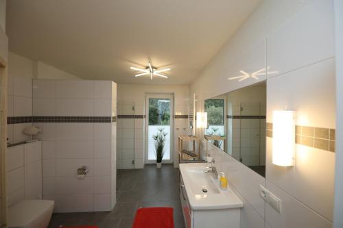 ein Badezimmer mit einem Waschbecken, einem WC und einem Spiegel in der Unterkunft Quartier Hohe Geest 15 - Nordseebrise - a69852 in Cuxhaven