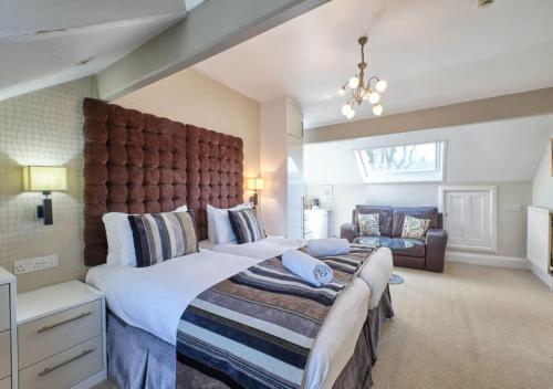 a large bedroom with a large bed and a couch at Grassington Lodge in Grassington