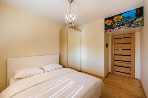sypialnia z łóżkiem i obrazem na ścianie w obiekcie Green District Apartment w Warszawie